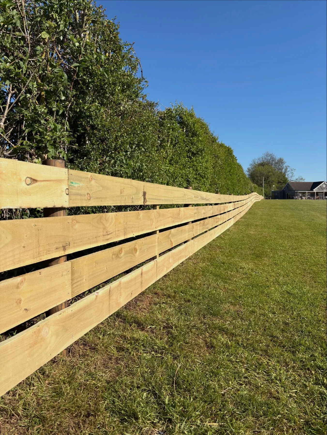 Timber ball-stop fencing beside a sports field